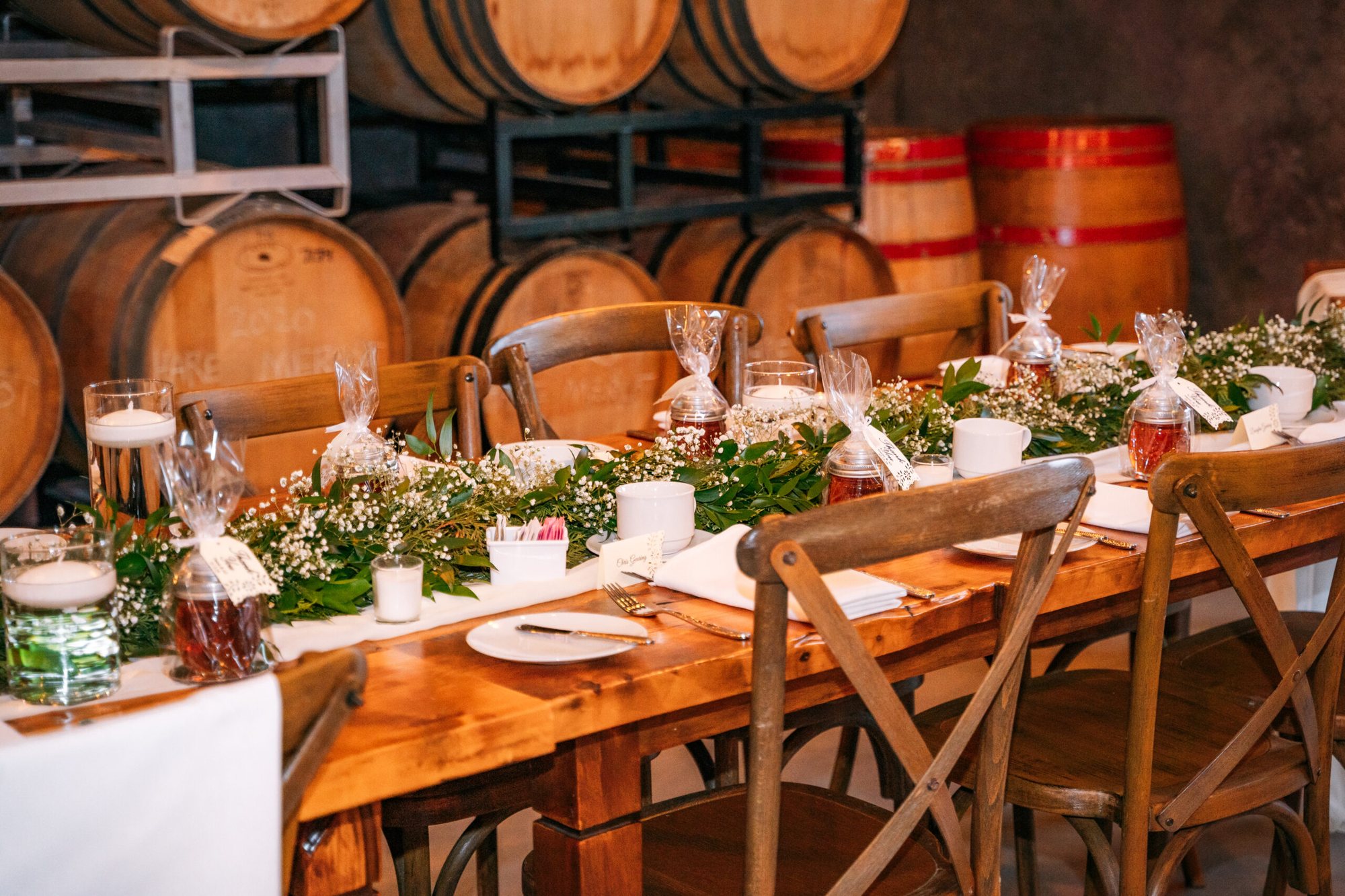 A long table set for a celebration among the wine barrels