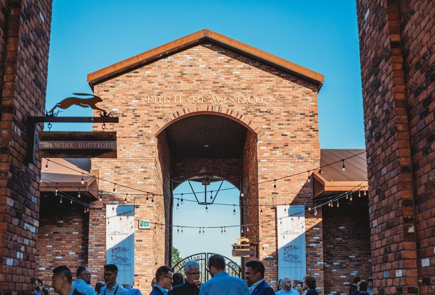 Guests gathered under the brick archway in the courtyard