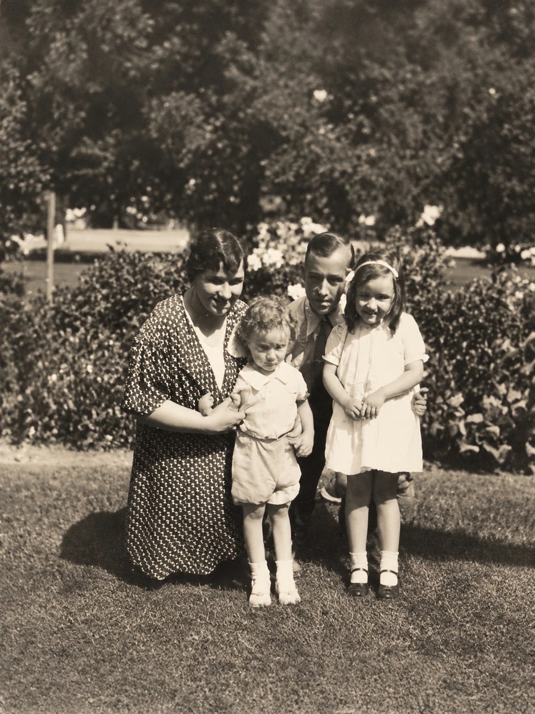 A family photograph from the archive: a woman and three children in a garden